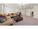 Upstairs living room featuring a sectional sofa, carpeted floors, and modern lighting at 1443 Bunker Dr, Davenport, FL 33836