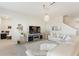Spacious living room with white leather sectional, modern entertainment center, and elegant chandelier at 1443 Bunker Dr, Davenport, FL 33836