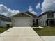 Charming single-story home featuring a two-car garage, neutral colors, and a well-manicured lawn at 1648 Heart Bar Rd, Kissimmee, FL 34744