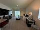 Comfortable living room area with modern furnishings, plush carpeting, and an open layout to the dining area at 1648 Heart Bar Rd, Kissimmee, FL 34744