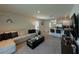 Spacious living room with a plush sofa, modern decor, an open layout, and a view into the kitchen at 1648 Heart Bar Rd, Kissimmee, FL 34744