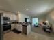 Open living space with a kitchen island, modern appliances, and a cozy living room area with neutral tones at 1648 Heart Bar Rd, Kissimmee, FL 34744