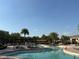 Large community pool area with ample lounge chairs, tables, and shady umbrellas at 1648 Heart Bar Rd, Kissimmee, FL 34744