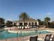 Community pool featuring lounge chairs, palm trees, and spacious deck for relaxing at 1648 Heart Bar Rd, Kissimmee, FL 34744