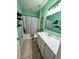 Bathroom with green walls, a shower-tub combo, and a white vanity with countertop at 1859 Shumard Ave, St Cloud, FL 34771