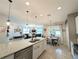 Open-concept kitchen with granite countertops, a stainless-steel dishwasher, and an adjacent dining area at 1859 Shumard Ave, St Cloud, FL 34771