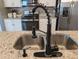 Granite countertops with a stainless steel sink and a modern black, coiled faucet at 1859 Shumard Ave, St Cloud, FL 34771