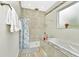 Elegant bathroom featuring a soaking tub with a showerhead and neutral colored tiling at 19182 Seaview St, Orlando, FL 32833