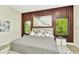 Stylish bedroom features a wood slat accent wall, large windows, and modern decor, creating a serene retreat at 19182 Seaview St, Orlando, FL 32833