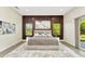 Stylish bedroom features a wood slat accent wall, large windows, and modern decor, creating a serene retreat at 19182 Seaview St, Orlando, FL 32833