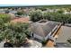 Aerial view of a home surrounded by mature trees and lush landscaping in a residential neighborhood at 207 Vervain Ave, Davenport, FL 33837
