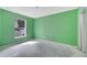 A bright green bedroom with natural light from the window, featuring unfinished floors at 207 Vervain Ave, Davenport, FL 33837