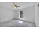 Empty room with a colorful ceiling fan and a sunlit window, showcasing its potential at 207 Vervain Ave, Davenport, FL 33837
