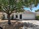 Charming single-story home with an attached garage and mature landscaping at 207 Vervain Ave, Davenport, FL 33837