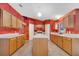 Spacious kitchen featuring wood cabinets, tiled floors, an island, and ample counter space at 207 Vervain Ave, Davenport, FL 33837
