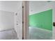 A view of a room with unfinished floors and vibrant green walls, showcasing a simple, open space at 207 Vervain Ave, Davenport, FL 33837
