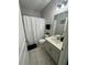 Bathroom with a white shower curtain, white tiled floors, and vanity with a sink at 209 Citrus Pointe Dr, Haines City, FL 33844