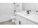 Modern bathroom with white cabinets, light countertops, sleek black hardware, and a tub/shower combo at 227 Sand Ridge Drive, Davenport, FL 33896