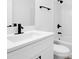 Bright bathroom features a white vanity with black fixtures and a shower-tub combo at 227 Sand Ridge Drive, Davenport, FL 33896