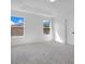 The bedroom has two windows, carpet flooring, and a white door at 227 Sand Ridge Drive, Davenport, FL 33896