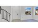 Bright entryway with white walls, modern windows, and stairs with a black iron railing at 227 Sand Ridge Drive, Davenport, FL 33896