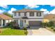 Inviting two-story home featuring a well-manicured lawn and an attached two-car garage at 227 Sand Ridge Drive, Davenport, FL 33896