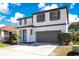Charming two-story home featuring a two-car garage, well-maintained lawn, and beautiful landscaping at 227 Sand Ridge Drive, Davenport, FL 33896