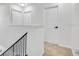Upstairs hallway with neutral carpet, black iron railing, and white doors at 227 Sand Ridge Drive, Davenport, FL 33896
