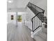Bright and open floor plan with gray wood-look flooring, columns, and a staircase with black metal railing at 227 Sand Ridge Drive, Davenport, FL 33896
