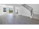 Spacious open living area showcasing light gray flooring, modern recessed lighting, and staircase with black railing at 227 Sand Ridge Drive, Davenport, FL 33896