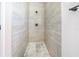 Modern shower featuring light grey tiles, dual shower heads, and stylish honeycomb-patterned flooring at 2437 Sw 147Th Ln, Ocala, FL 34473