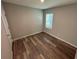 Bedroom with light gray walls, wood-look floors and a window at 2439 White Lilly Dr, Kissimmee, FL 34747