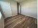 Bedroom view with wood-look flooring and natural light from a window and entry door at 2439 White Lilly Dr, Kissimmee, FL 34747