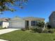 Landscaped single-story home with a well-manicured lawn and a two-car garage at 2439 White Lilly Dr, Kissimmee, FL 34747