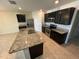 Bright kitchen with an island, stainless steel appliances, granite countertops, and dark wood cabinets at 2439 White Lilly Dr, Kissimmee, FL 34747