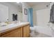 Clean bathroom with a wooden vanity, tiled floors, and a combined shower and bathtub with blue accents at 253 Granada Blvd, Davenport, FL 33837