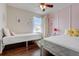 Bright bedroom with two twin beds, hardwood floors and butterfly decor creating a playful and cozy space at 253 Granada Blvd, Davenport, FL 33837