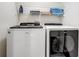 Bright laundry area with white Whirlpool washer and dryer and shelving for towels at 253 Granada Blvd, Davenport, FL 33837