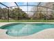 Backyard in-ground pool with screened enclosure and a view of mature trees at 253 Granada Blvd, Davenport, FL 33837