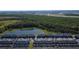 Aerial view of a townhouse community bordered by a lush nature preserve and pond at 2605 Reading Trl, Kissimmee, FL 34746