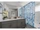 Bright bathroom with a double vanity, large mirror, and a tub with a leaf-patterned shower curtain at 2605 Reading Trl, Kissimmee, FL 34746
