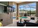 Cozy screened-in patio with comfortable seating, TV, and a view of the pool area at 2605 Reading Trl, Kissimmee, FL 34746