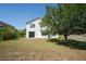 Spacious backyard with lush lawn, mature tree, and a view of the home's exterior at 2764 Patrician Cir, Kissimmee, FL 34746