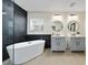 Bright bathroom featuring a modern tub, sleek vanities, round mirrors, and contemporary lighting at 2764 Patrician Cir, Kissimmee, FL 34746