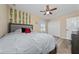 Bedroom with neutral tones featuring a ceiling fan, decorative plants, and a cozy gray headboard bed at 2764 Patrician Cir, Kissimmee, FL 34746