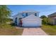 Charming two-story home featuring a white exterior, brick driveway, and well-maintained landscaping at 2764 Patrician Cir, Kissimmee, FL 34746