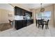Eat-in kitchen showcasing black cabinets, stainless appliances, tile floors, and natural light at 2764 Patrician Cir, Kissimmee, FL 34746