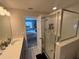 A bathroom with a glass-enclosed shower next to an open doorway showcasing a bedroom at 2883 Narcoossee Commons Way, St Cloud, FL 34771