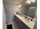 Bathroom featuring a double sink vanity, bright lighting, and a glass-enclosed shower at 2883 Narcoossee Commons Way, St Cloud, FL 34771