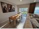 Bright dining room featuring a wooden table, modern chairs, and sliding glass doors to the outdoor area at 2883 Narcoossee Commons Way, St Cloud, FL 34771